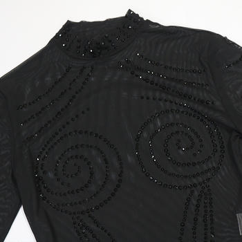 Black garment with bead embellishments on a white background