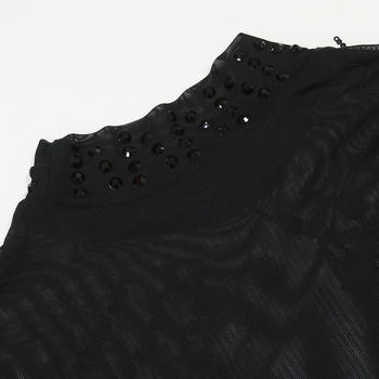 Black lace garment with bead embellishments on a white background