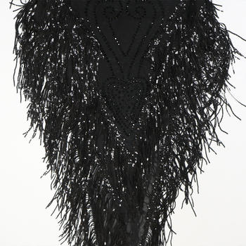 Black sequin dress with feathered overlay on a white background