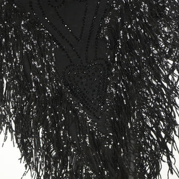 Close-up of a black beaded garment with intricate patterns on a white background