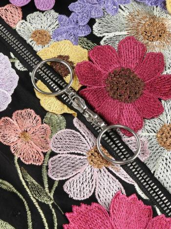 Embroidered floral design with a keychain on a black background