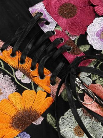 Close-up of floral embroidered shoes with black laces.