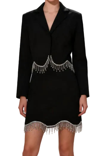 Black dress with silver fringe details on a blurred city street background