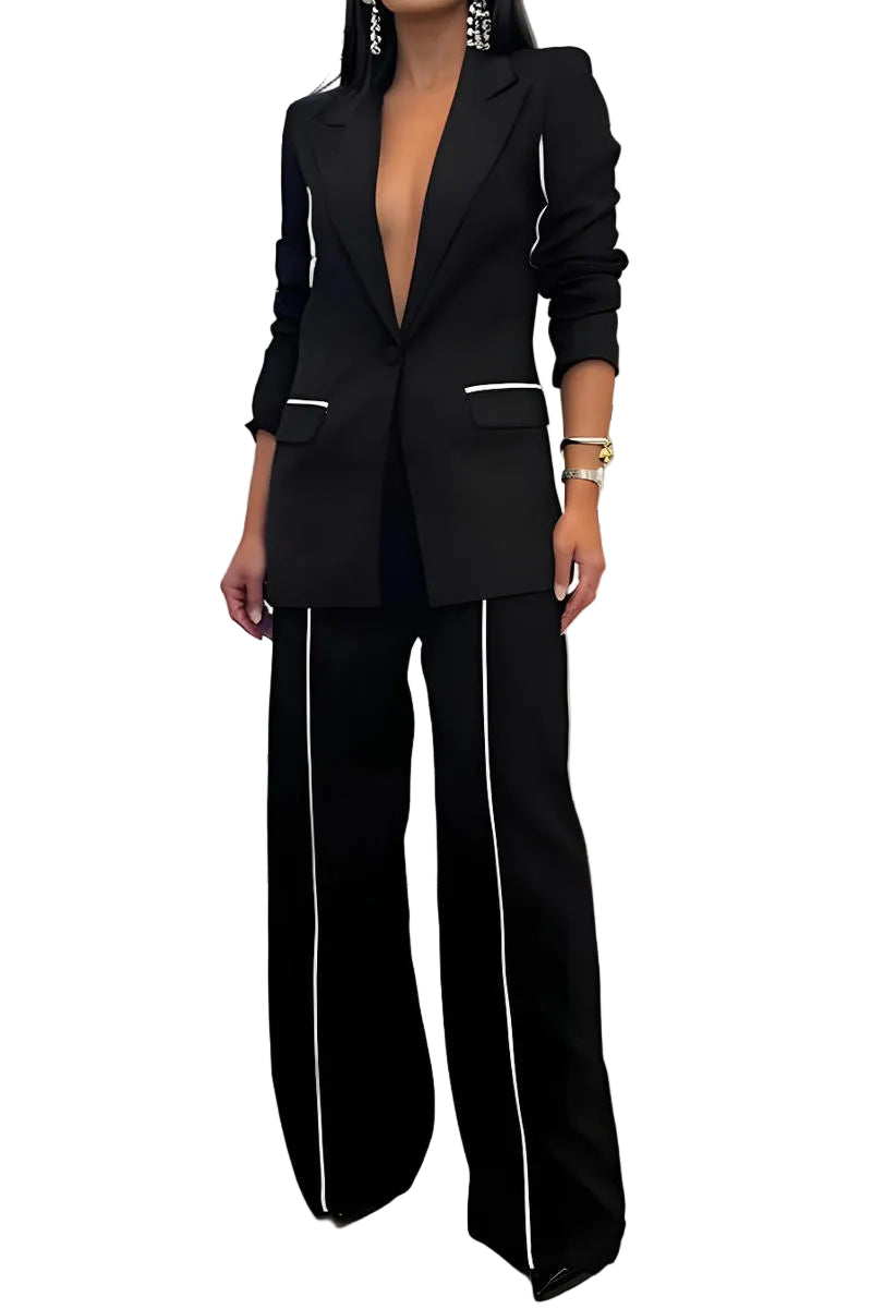 Person wearing a black suit with white piping in an indoor setting