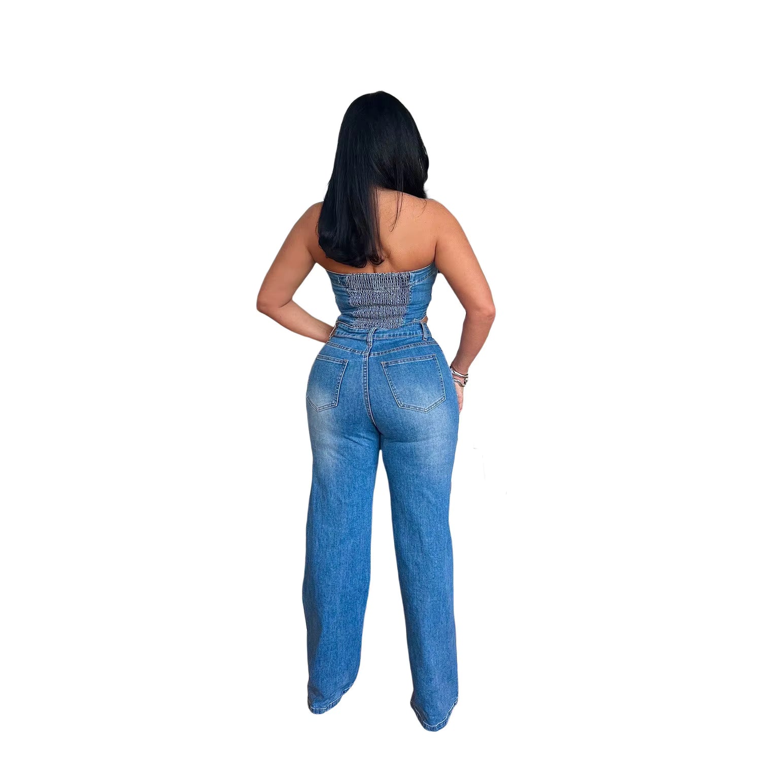 Woman wearing a blue denim jumpsuit on a white background
