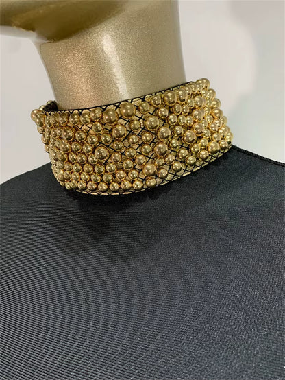 Gold beaded choker on a mannequin with a plain background
