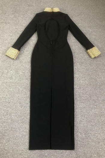 Black dress with gold embellishments on sleeves and neckline on a gray background