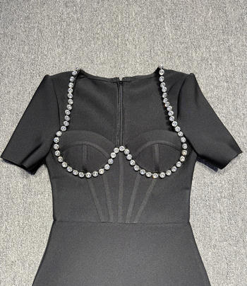 Close-up of rhinestone bust detail on feather hem midi dress