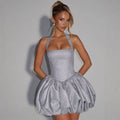 Woman wearing a sparkly silver dress against a plain background