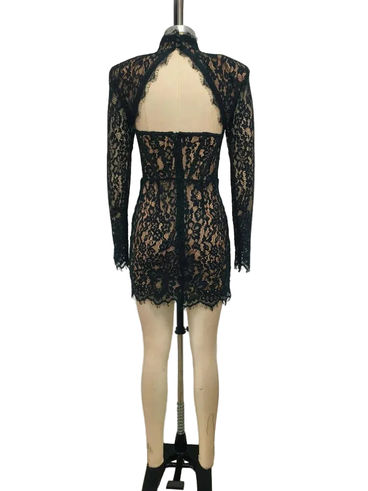 Black lace dress on a mannequin against a plain background
