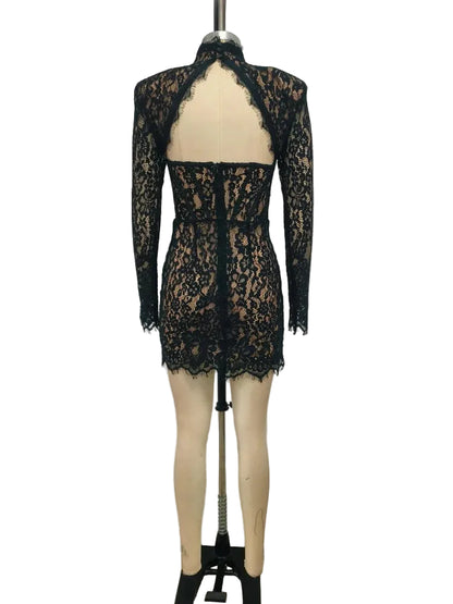 Black lace dress on a mannequin against a plain background