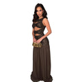 Woman wearing a black sequin dress with cut-out design and brown bottom on a white background