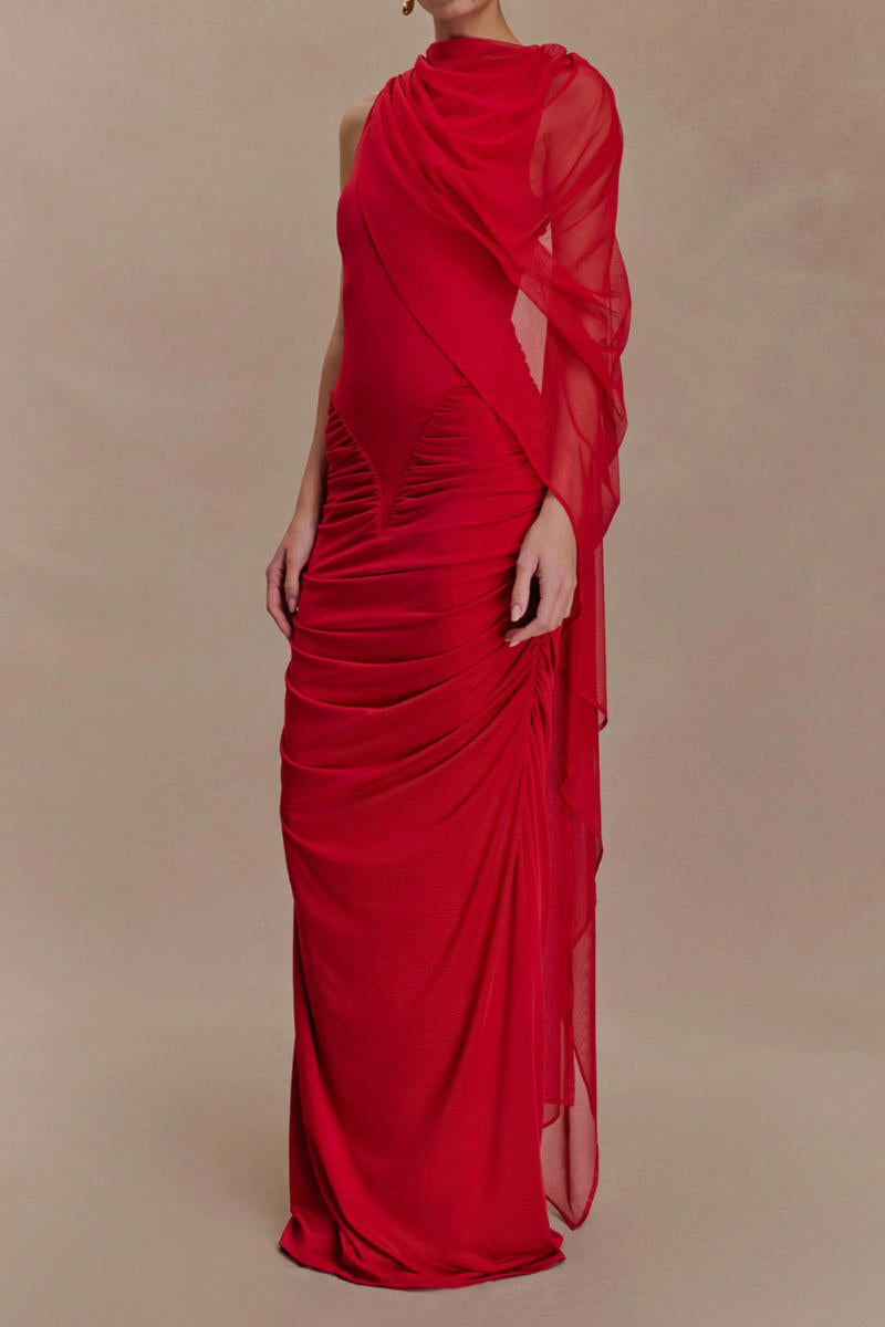 Red evening gown with sheer overlay on a beige background